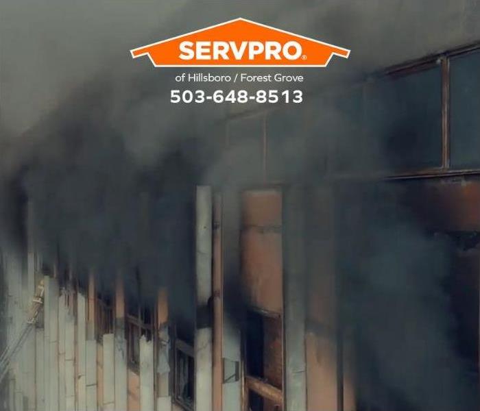 Smoke billows out of windows in a commercial property.